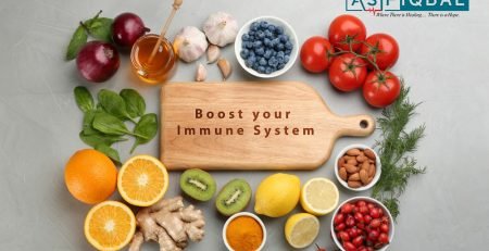 A variety of fruits, vegetables, and natural ingredients displayed in a flat lay around a wooden board with the text "Boost your Immune System."